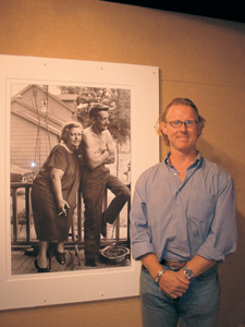 photo by Cindy Cornwell Pulitzer Prize-winning photographer and filmmaker, David Turnley, during the opening of the St. Francis exhibition.  (background) Photo of McClellan Street couple on their back porch, behind the old post office in Fort Wayne, was taken during David’s high school days at Elmhurst.