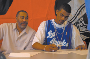 Waynedale News file photo James Hardy, of Elmhurst High School commits to Indiana University in both football and basketball on Wednesday, February 4, 2004 in the Elmhurst High School Community Room.  Hardy’s father, James Hardy II, witnesses the event.